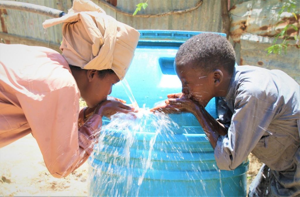A boy pumps clean water from a new well